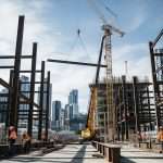 Melbourne steel beam construction site with cranes and workers showing Victoria's $90 billion infrastructure boom and commercial structural steel demand