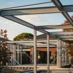 Steel frame structure of residential building under construction with workers on site